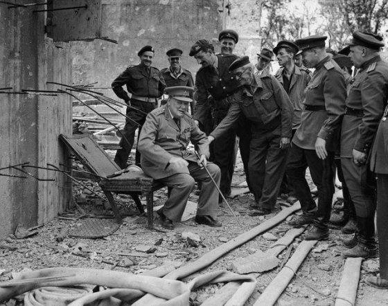 უინსტონ ჩერჩილი ჯდება ჰიტლერის სკამზე.უფრო სწორედ რაც მისგან დარჩა.1945 წელი.