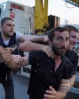 პოლიციის ფორმიანები ღიმილიანი სახით აკავებენ შენობიდან გამოძევებულ მოქალაქეს